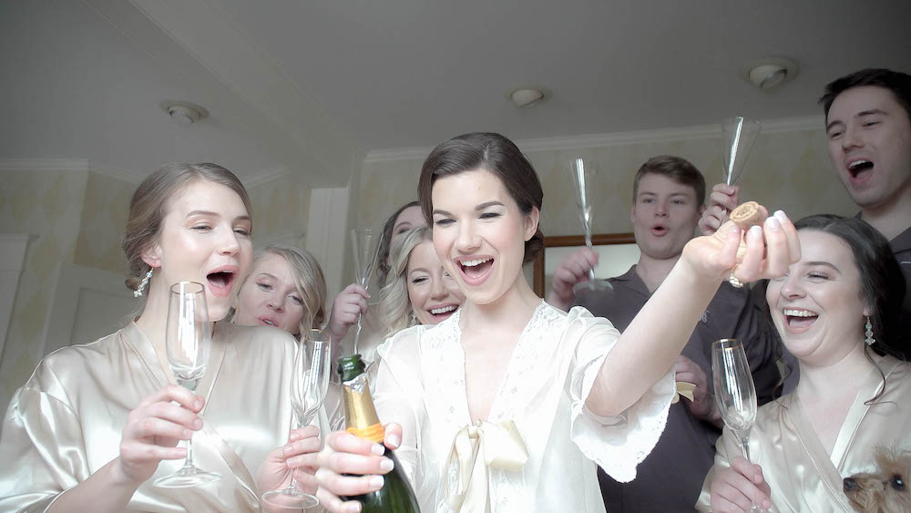 Bridesmaids popping champagne