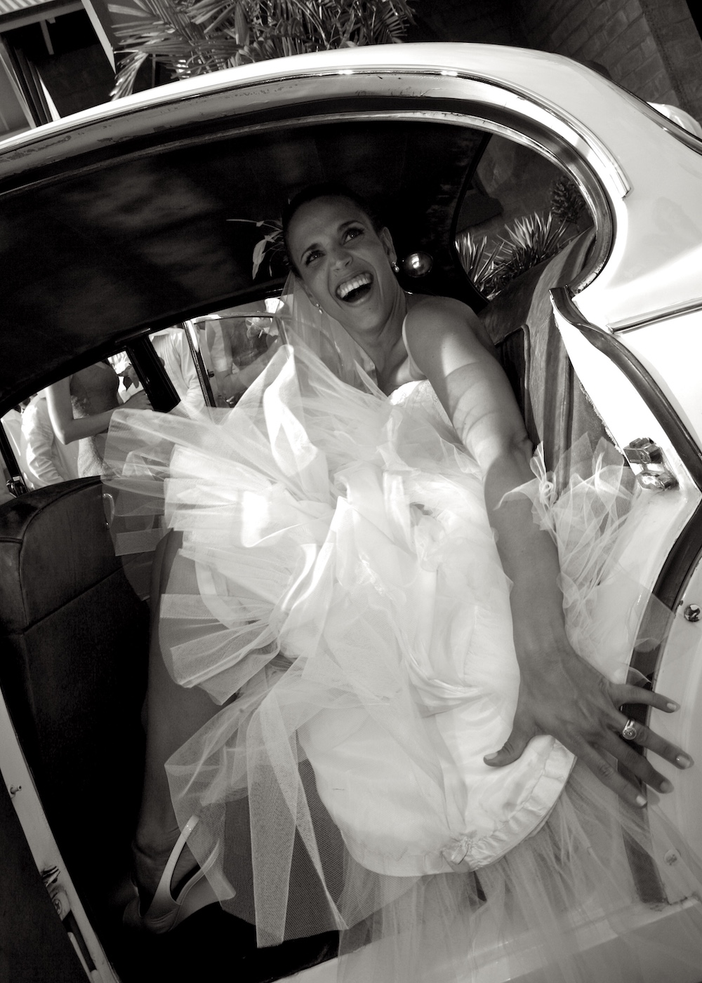 Bride getting into vintage car