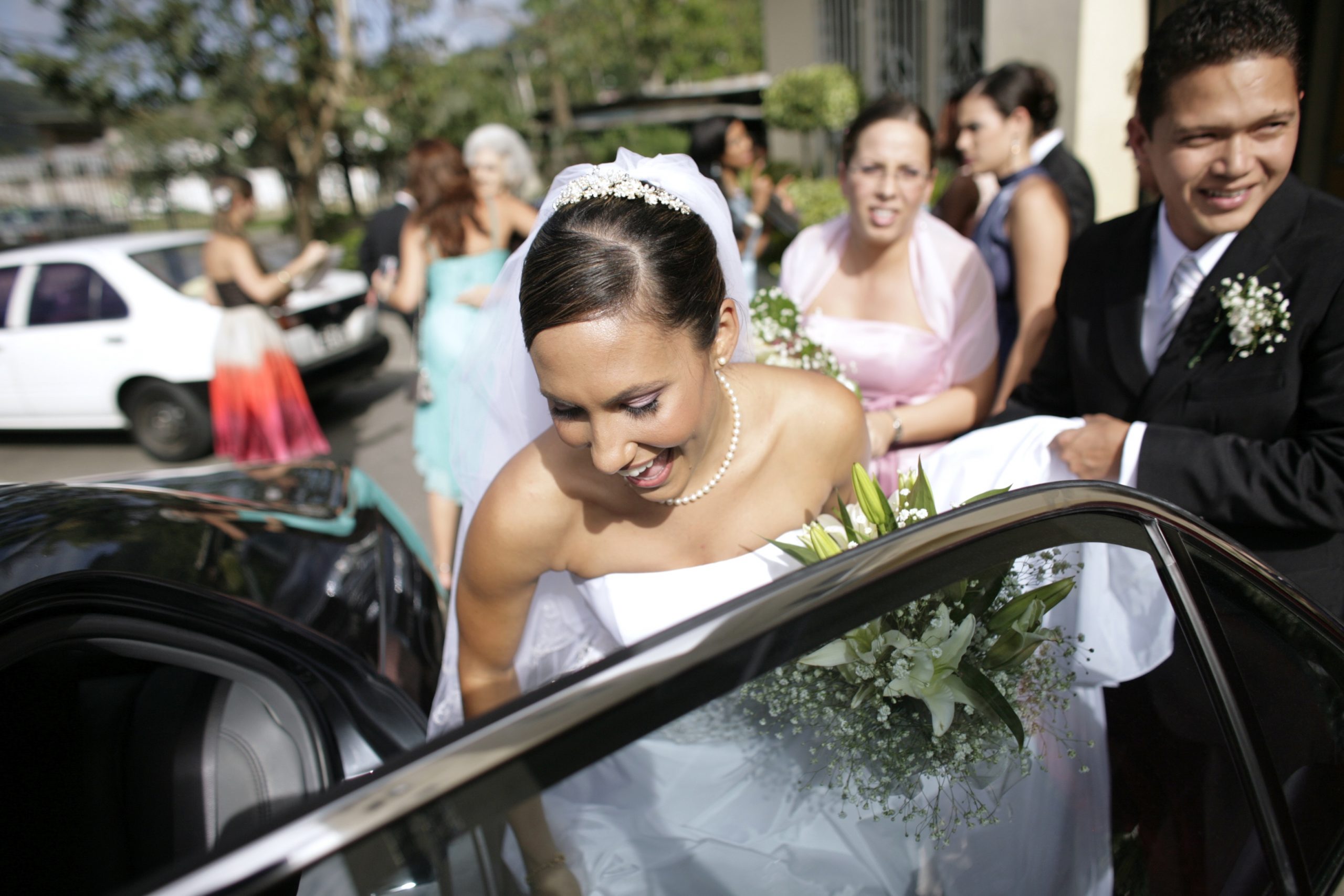 Bride and groom getting into car